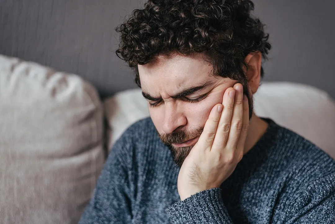 Man holding his jaw in pain from a toothache